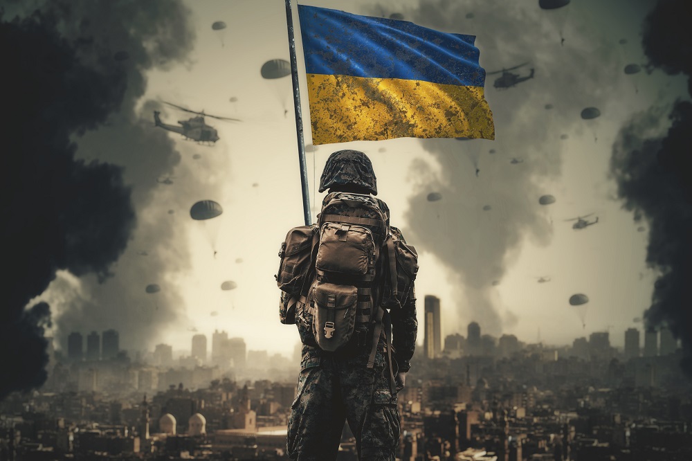 A Ukrainian soldier stands with a Ukrainian flag in his hand and